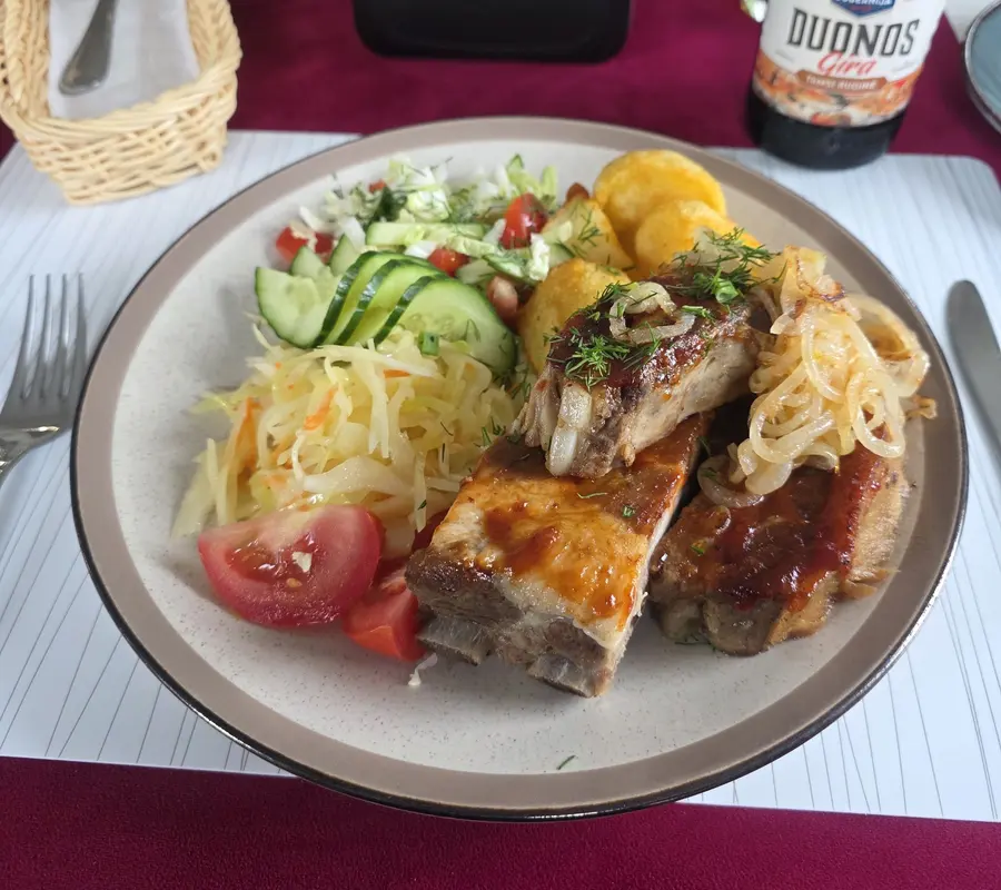 Šonkauliukai su svogūnais, keptomis bulvėmis ir daržovių salotomis